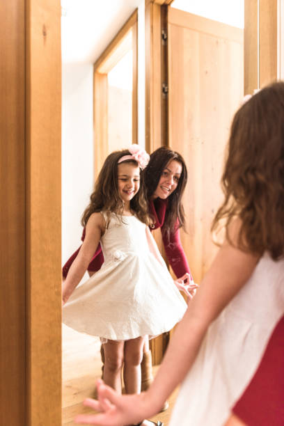 istock mother and daughter dressing up at the mirror 666773316