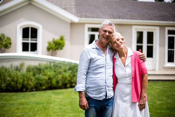 istock Senior couple with arms around standing in yard 666773362