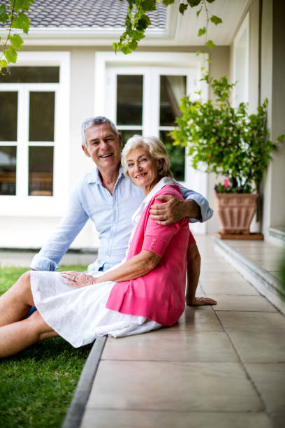 istock Senior couple sitting on steps outside house in yard 666775734