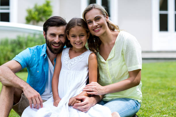 istock Mother and father with daughter sitting in yard 666782528