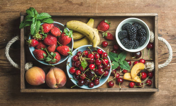 istock Summer fresh fruit and berry variety in rustic wooden tray 666785214