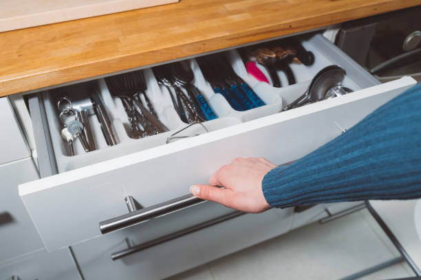 istock Close up of hand opening a white kitchen drawer 666785330