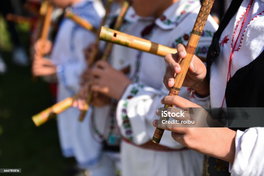 People in romanian traditional costumes People in romanian traditional costumes singing at wooden flutes Tradition Stock Photo