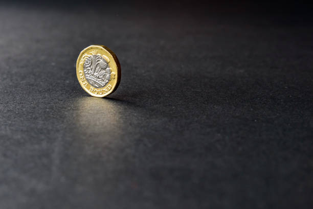 новая британская монета фунт стерлингов на темном фоне - one pound coin british currency coin paper currency стоковые фото и изображения