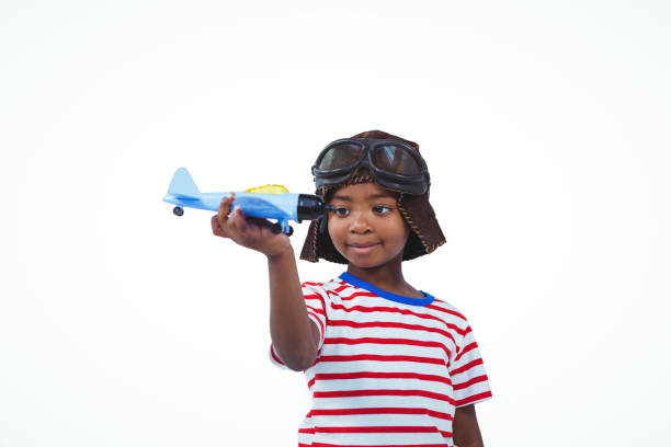 Smiling boy playing with toy airplane on white screen