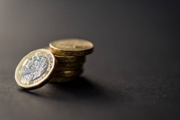 nueva moneda británica de una libra esterlina sobre fondo oscuro - british coin fotografías e imágenes de stock