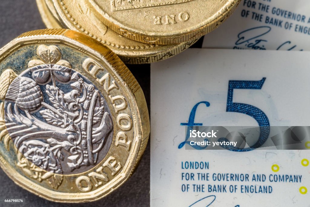 New five sterling pounds note and one pound coin New five sterling pounds note and one pound coin. British Currency Stock Photo