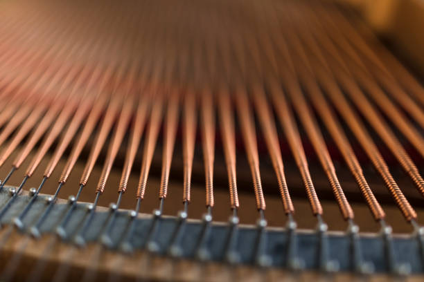 close-up shot of the inside of a piano where the strings and dampers are visible. - piano interior imagens e fotografias de stock