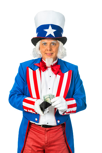 Patriotic woman holds large US flag and laughs. She has on a tophat too.