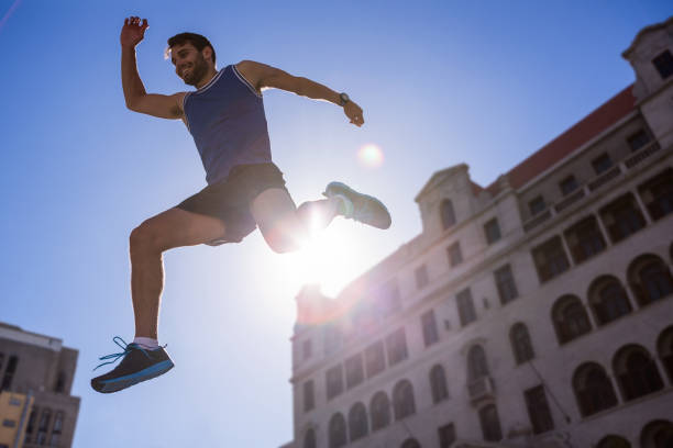 istock Handsome athlete leaping in front of building 666820218