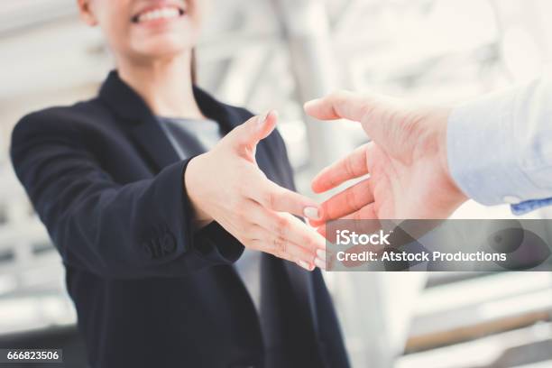 Young Businesswoman Going To Make Handshake With A Businessman Stock Photo - Download Image Now