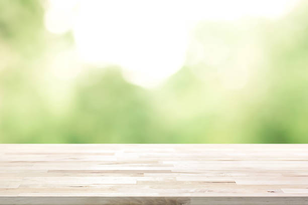istock Wood table top on  blur abstract natural green background 666823540