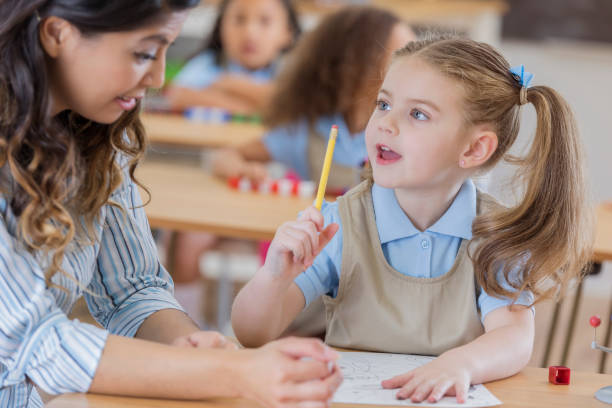 istock Teacher helps young schoolgirl 666835496
