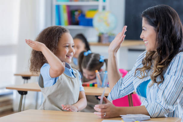 istock Proud teacher gives student a high five in math class 666835518