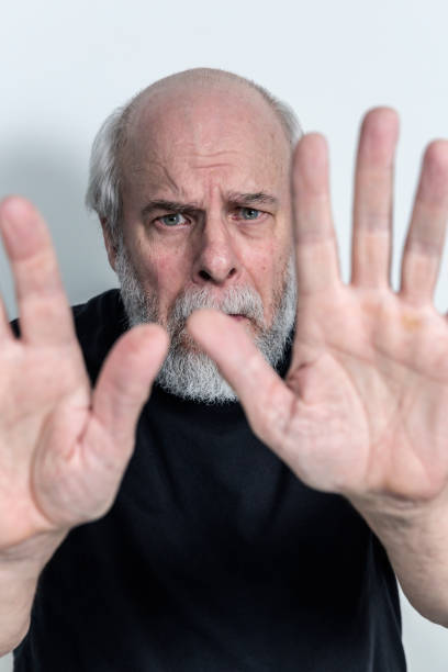 istock Anxious Scared Senior Adult Man Two Hands Stop Sign 666871198