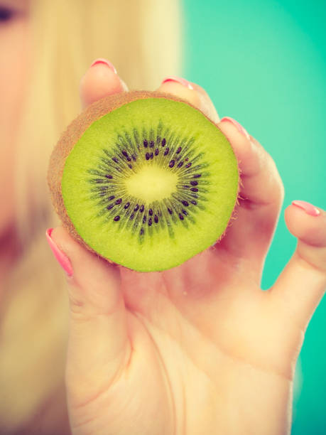 istock Woman holding green kiwi fruit 666875894