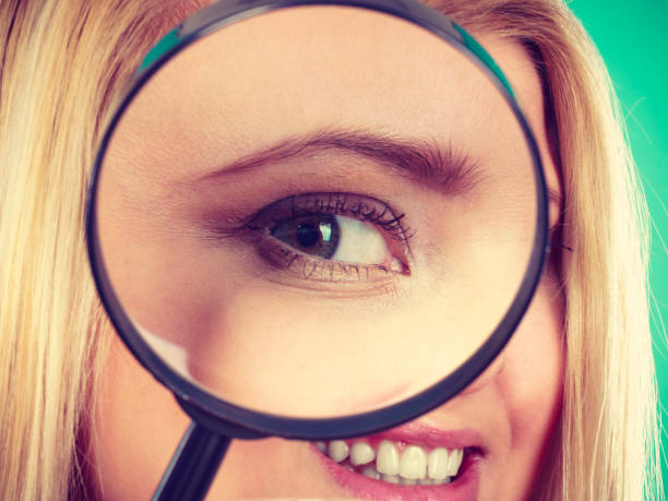 istock Woman looking through magnifying glass 666875956