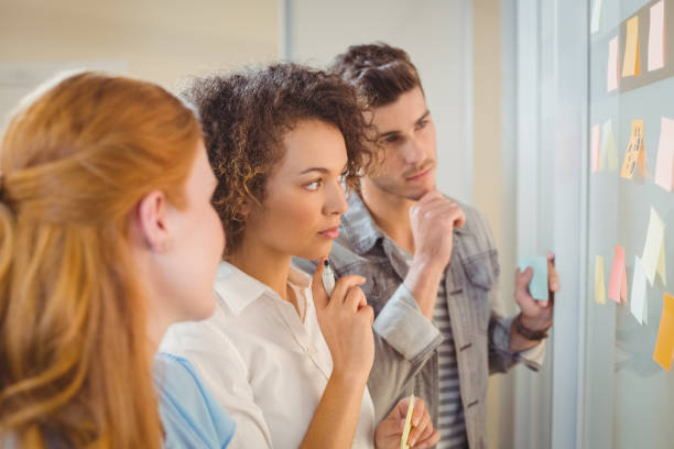 istock Businesswoman touching adhesive note on glass 666876400