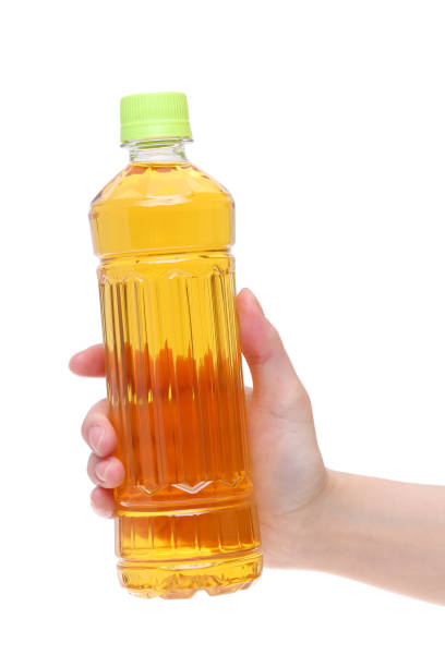 Hand holding bottle of tea isolated on white background