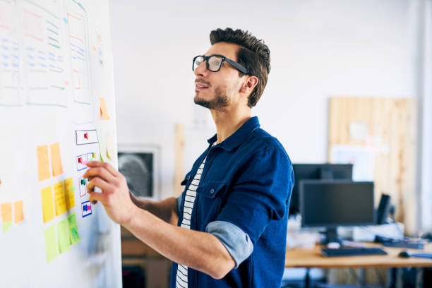 Ux specialist designing new application layout on whiteboard stock photo