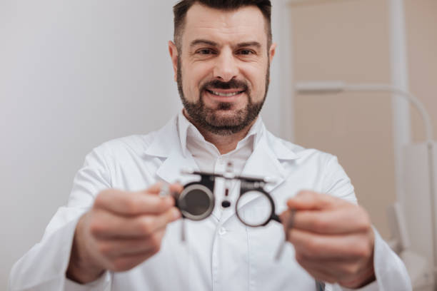 istock Cheerful friendly ophthalmologist holding eye test glasses 666890206