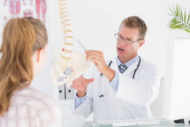 istock Doctor showing his patient a spine model 666890276