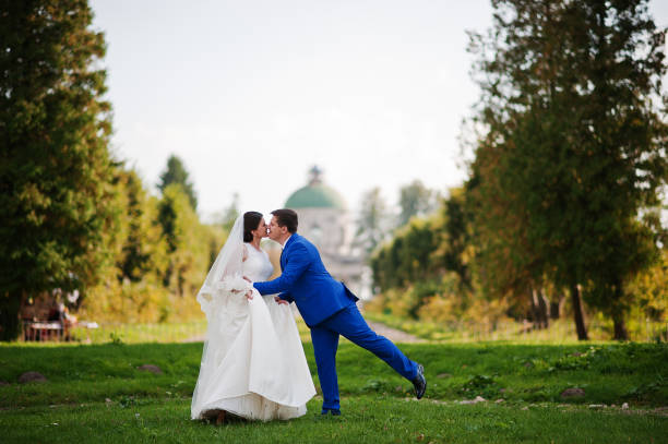 lovely bride and groom embracing and kissing, enjoying their happy day together and smiling.