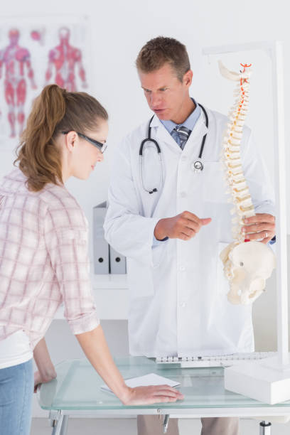 istock Doctor explaining a spine model to patient 666890684