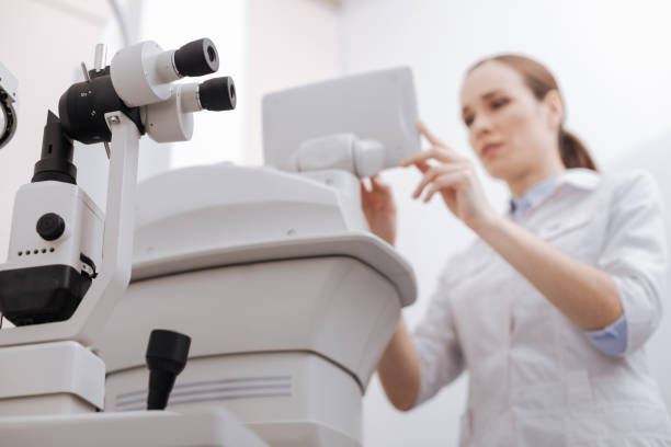 istock Nice pleasant woman working with eye testing equipment 666890866