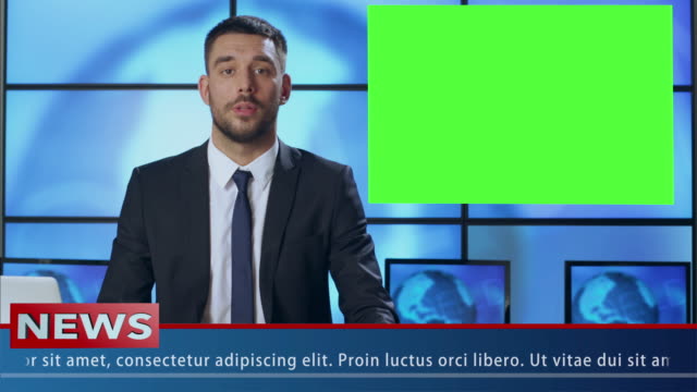 Male News Presenter in Broadcasting Studio With Green Screen Display for Mockup usage.