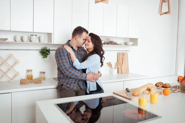 istock Happy couple hugging in the white loft stile kitchen 666897636