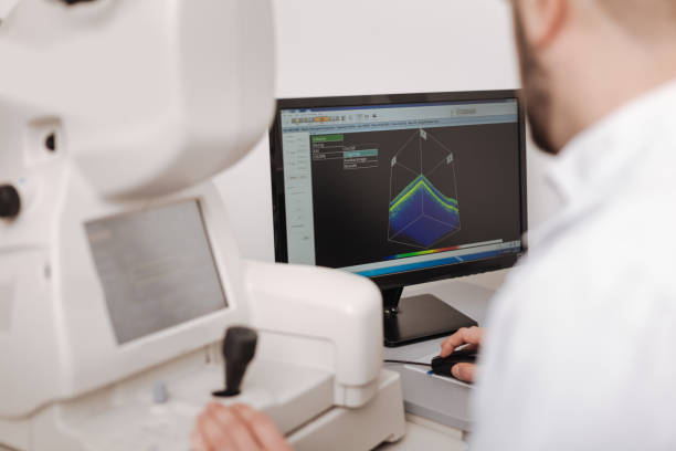 istock Serious experienced optometrist looking at the monitor 666898566