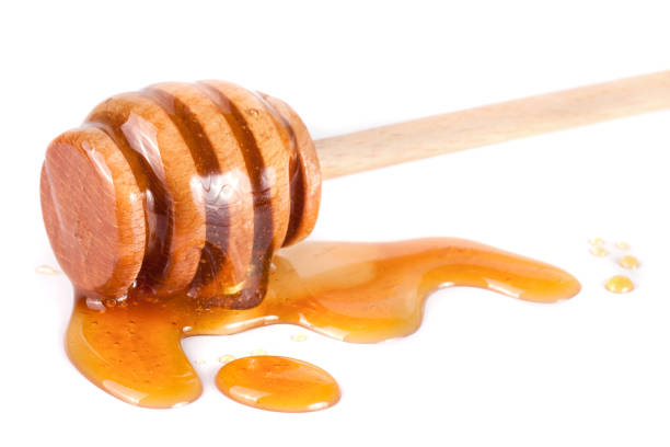 istock Honey stick with flowing honey isolated on white background 666901704