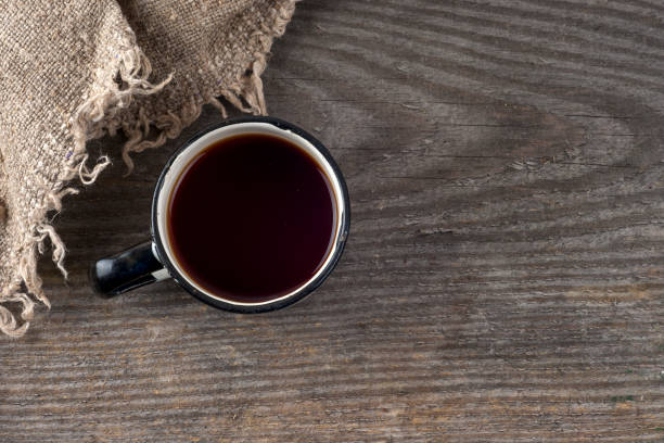 istock Festive tea party. burlap hessian sacking and cup with tea over rustic wooden background. 666908590