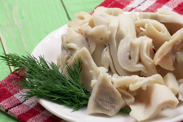 istock sliced squid on a plate on a green wooden background 666908764