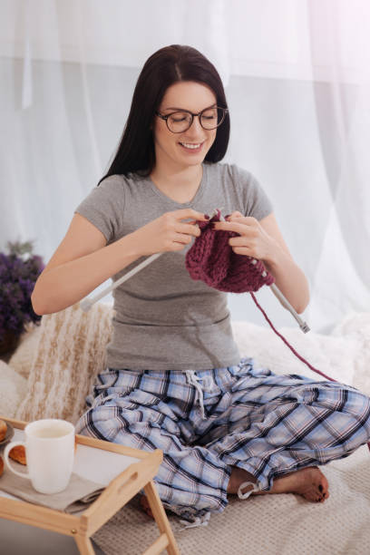 istock Talented young woman practicing knitting at home 666912000