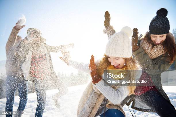 Boys Throwing Snowballs Right On The Girls Stock Photo - Download Image Now - Friendship, Winter, Snowball