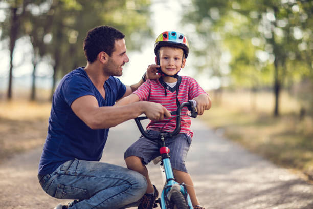 istock Cute small boy on bicycle enjoying in nature with father. 666915602