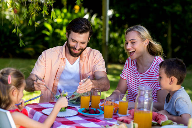 istock Family enjoying breakfast at table in yard 666915614