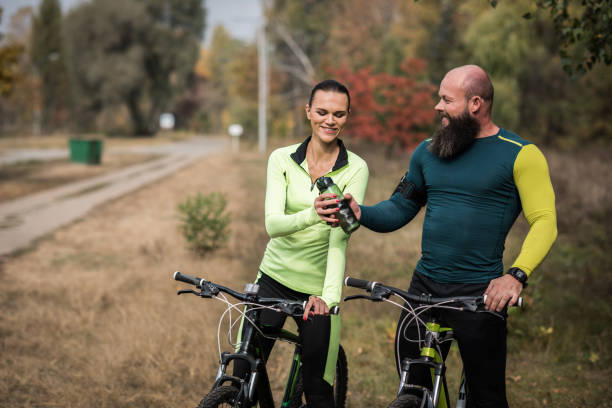 istock Couple of cyclists resting in park 666918964