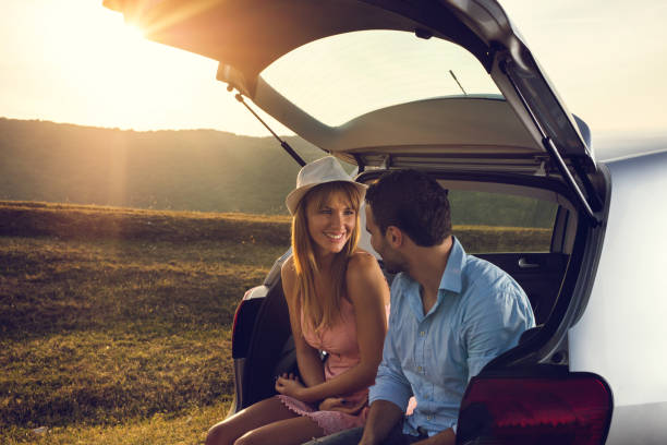 istock Smiling couple relaxing in car trunk and talking. 666919360