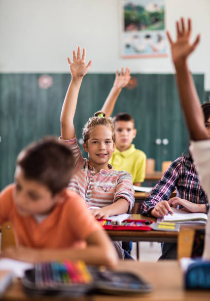 istock School kids raising hands to answer the question during lecture. 666923278