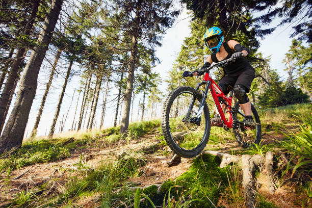 istock Female mountainbiker riding downhill in forest 666927656