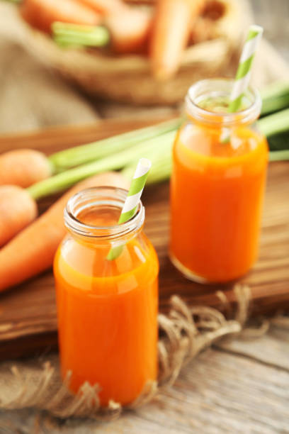 istock Fresh carrot juice in bottles on a grey wooden table 666930490