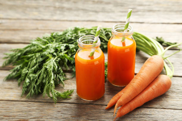 istock Fresh carrot juice in bottles on a grey wooden table 666930676
