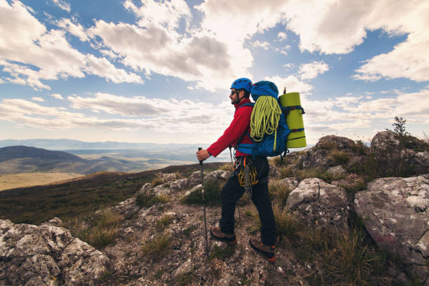 istock Traveler Man with backpack mountaineering 666934396