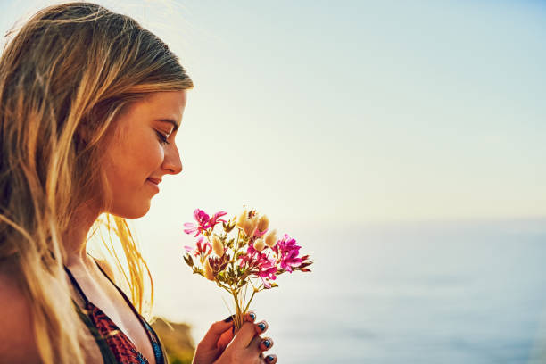 Shot of a happy young woman holding a bunch of flowers while standing outside
