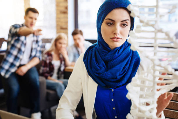 istock Smart muslim woman studying DNA model 666939332