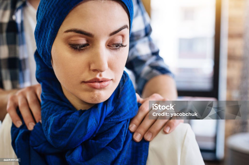 Muslim woman beign herrased by representative of another group Dont touch me. Pleasant muslim woamn sitting while representative of another religious group herassing her Sexual Harassment Stock Photo