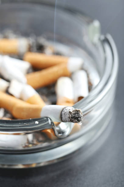 istock Cigarette butts with ash in ashtray on black background 666941940